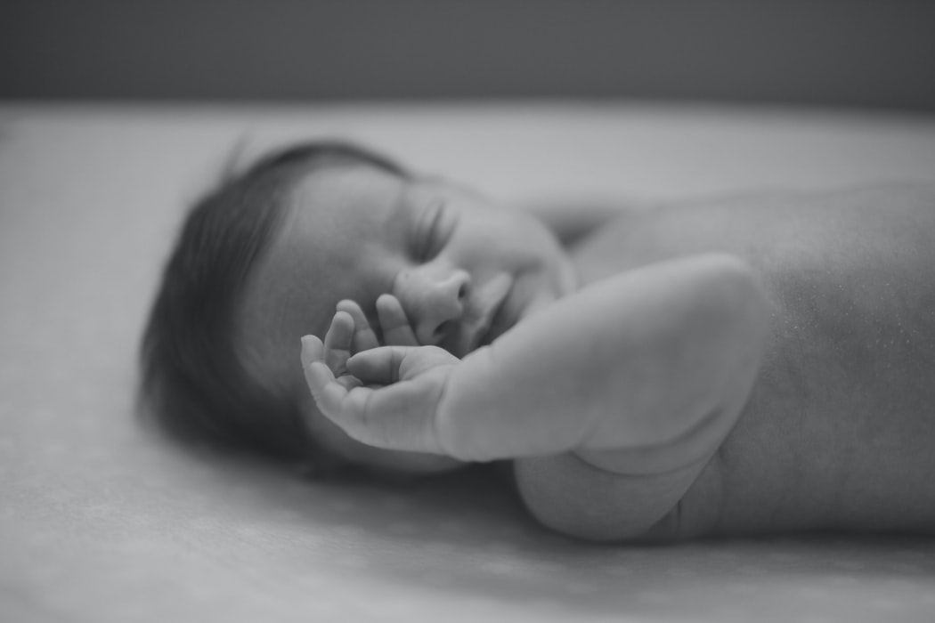 black and white photo of baby with closed eyes