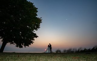 newlyweds embracing at dusk