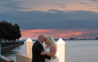 bride and groom in a posed photo with sunset in background