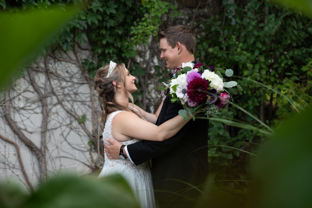 bride and groom hands holding bouquet at small wedding